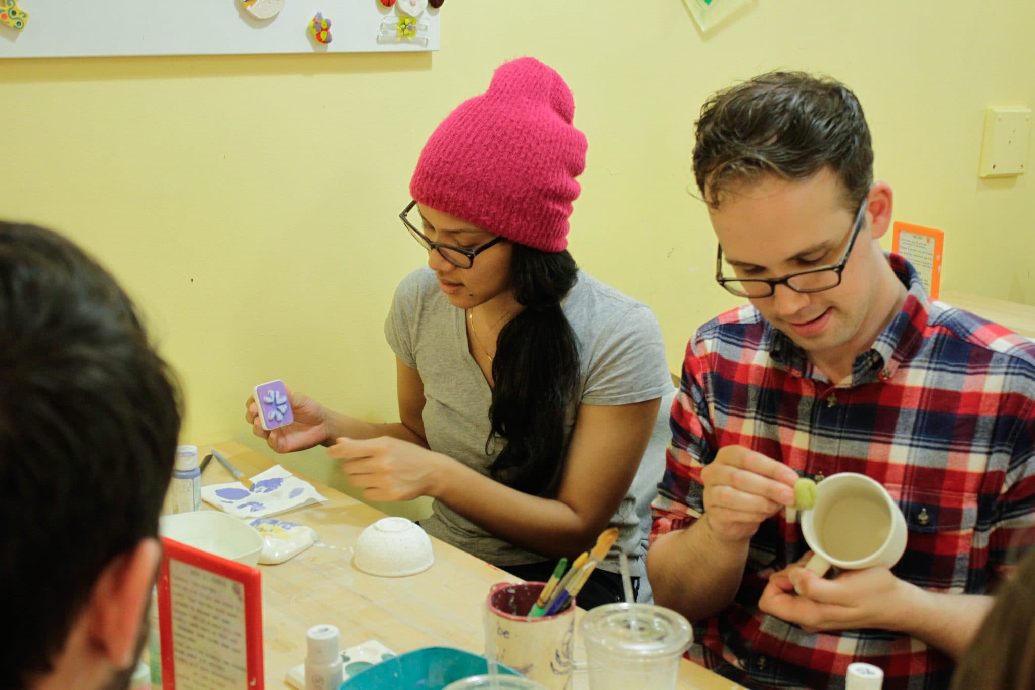 Adults painting pottery